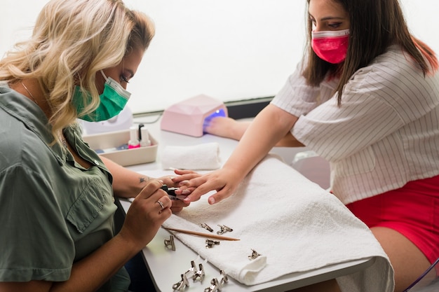 hispanic young female woman doing manicure with brazilian professional fiberglass nail detail 394926 422